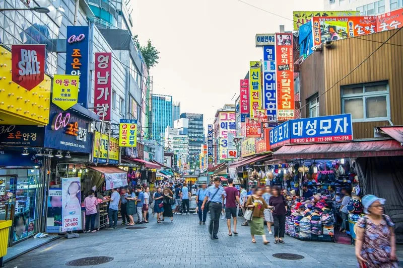 Guide handing over a hotteok pancake among the stalls of Namdaemun Market on a seoul food tours street-food walk in Seoul, South Korea